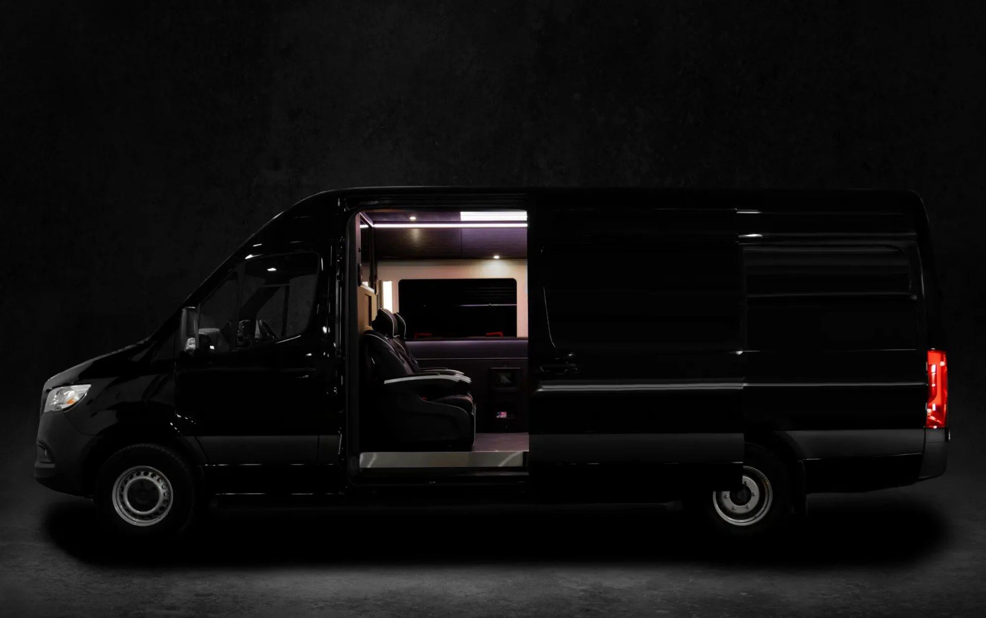 A black van with the door open at night.
