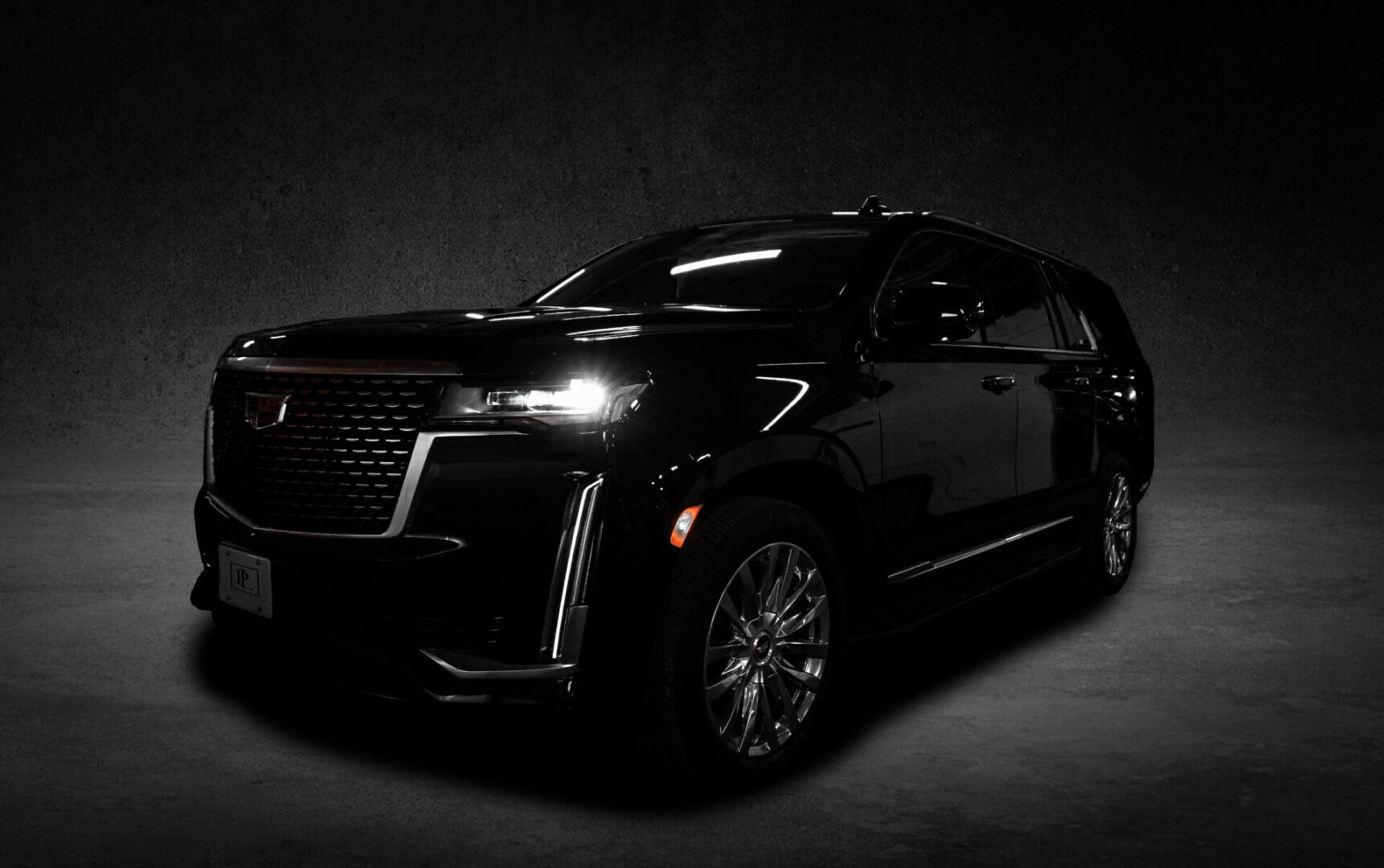 A black suv is parked in the dark.