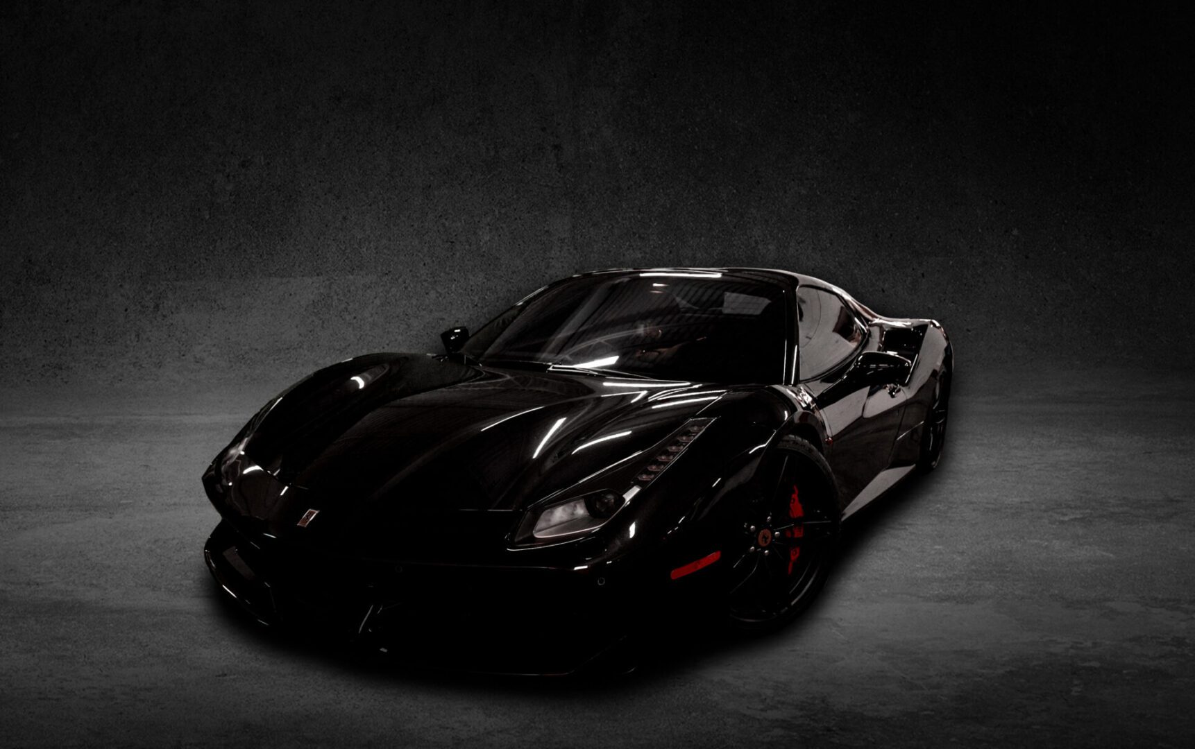 A black sports car is parked in the dark.