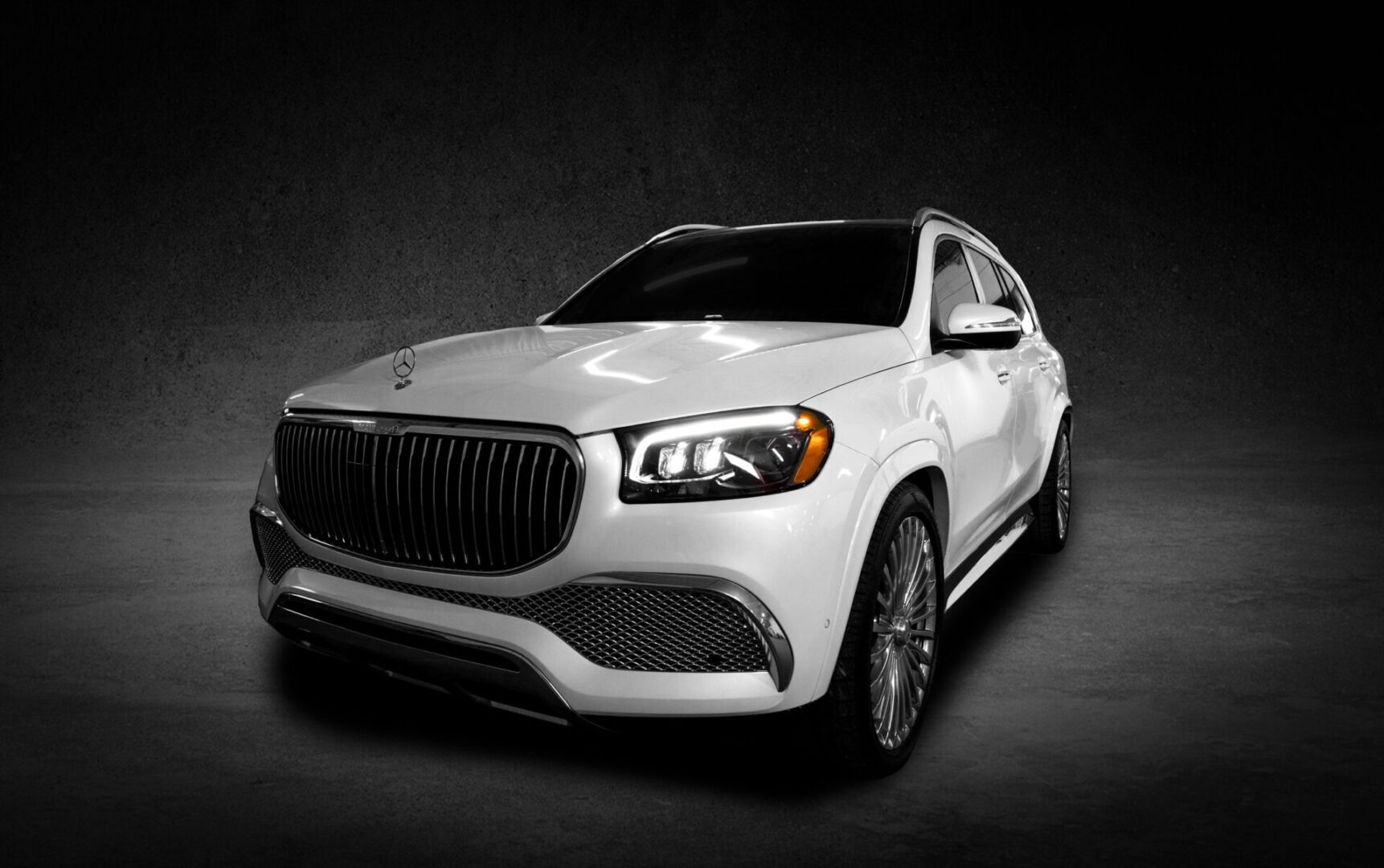 A white car is parked in the dark.