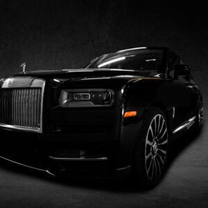 A black car is parked in the dark.