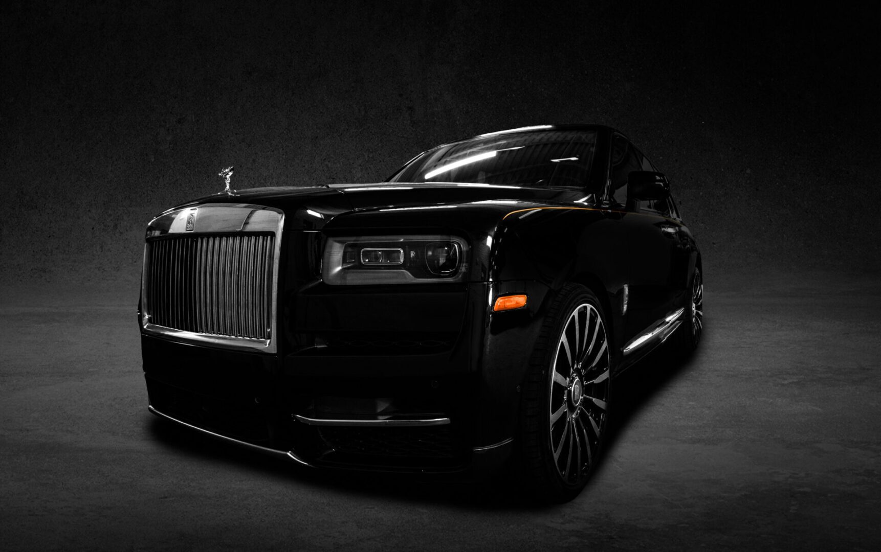 A black car is parked in the dark.